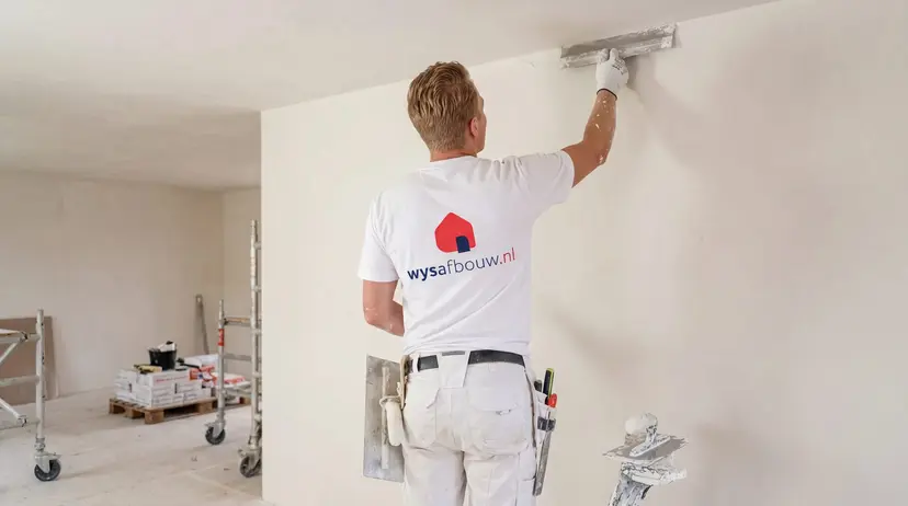 Stukadoor van WYS Afbouw werkt een wand strak af