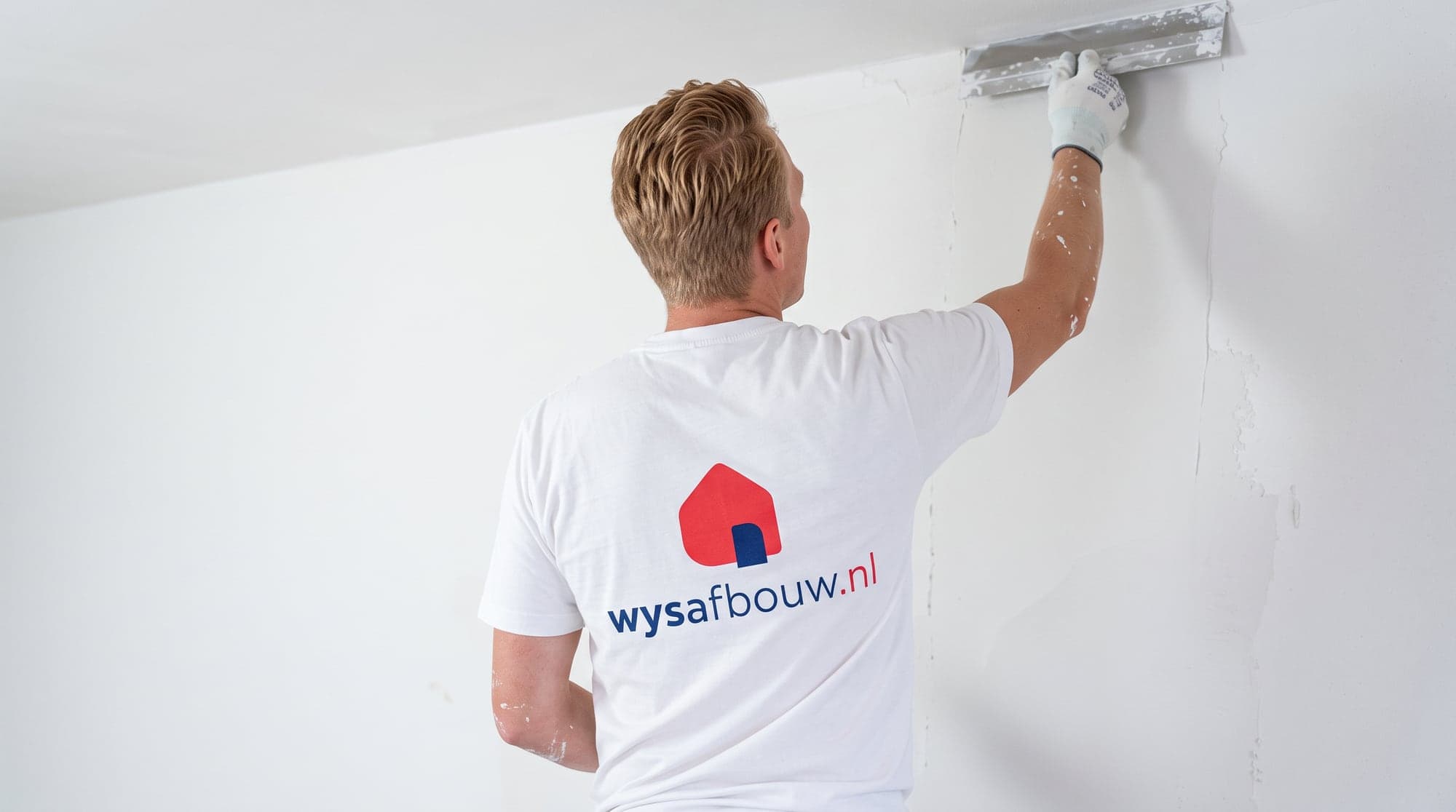 Stukadoor van WYS Afbouw werkt een wand strak af